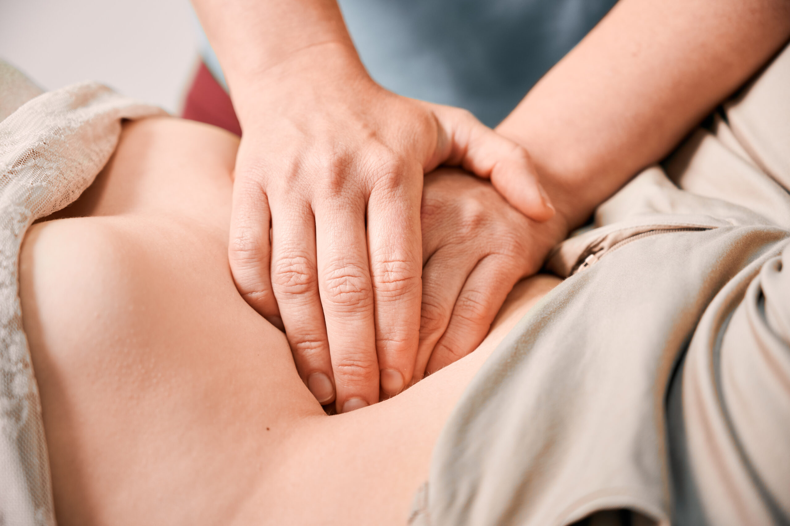 doctor examining female patient stomach.
