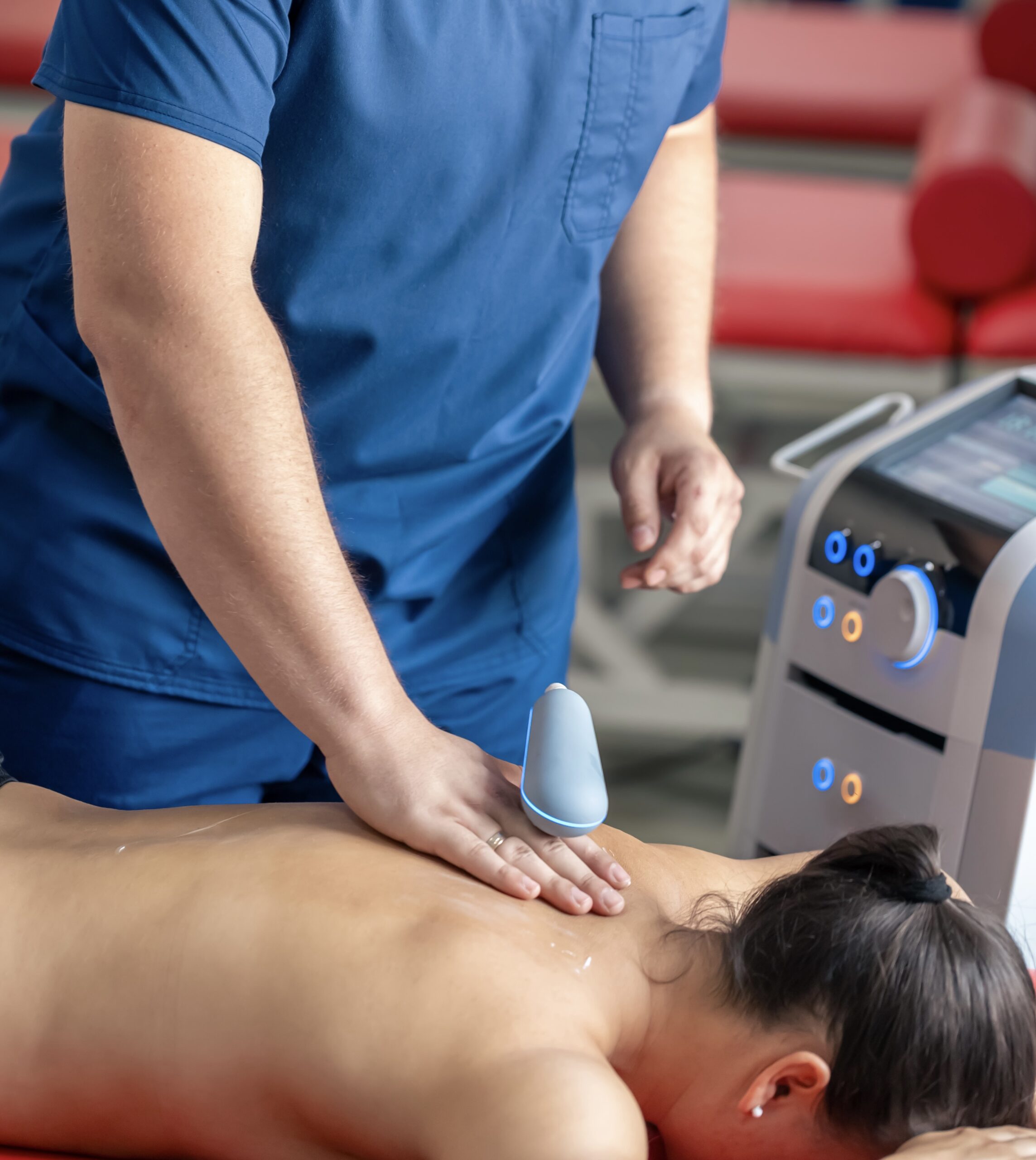 doctor using machine to treat the back of a patient.